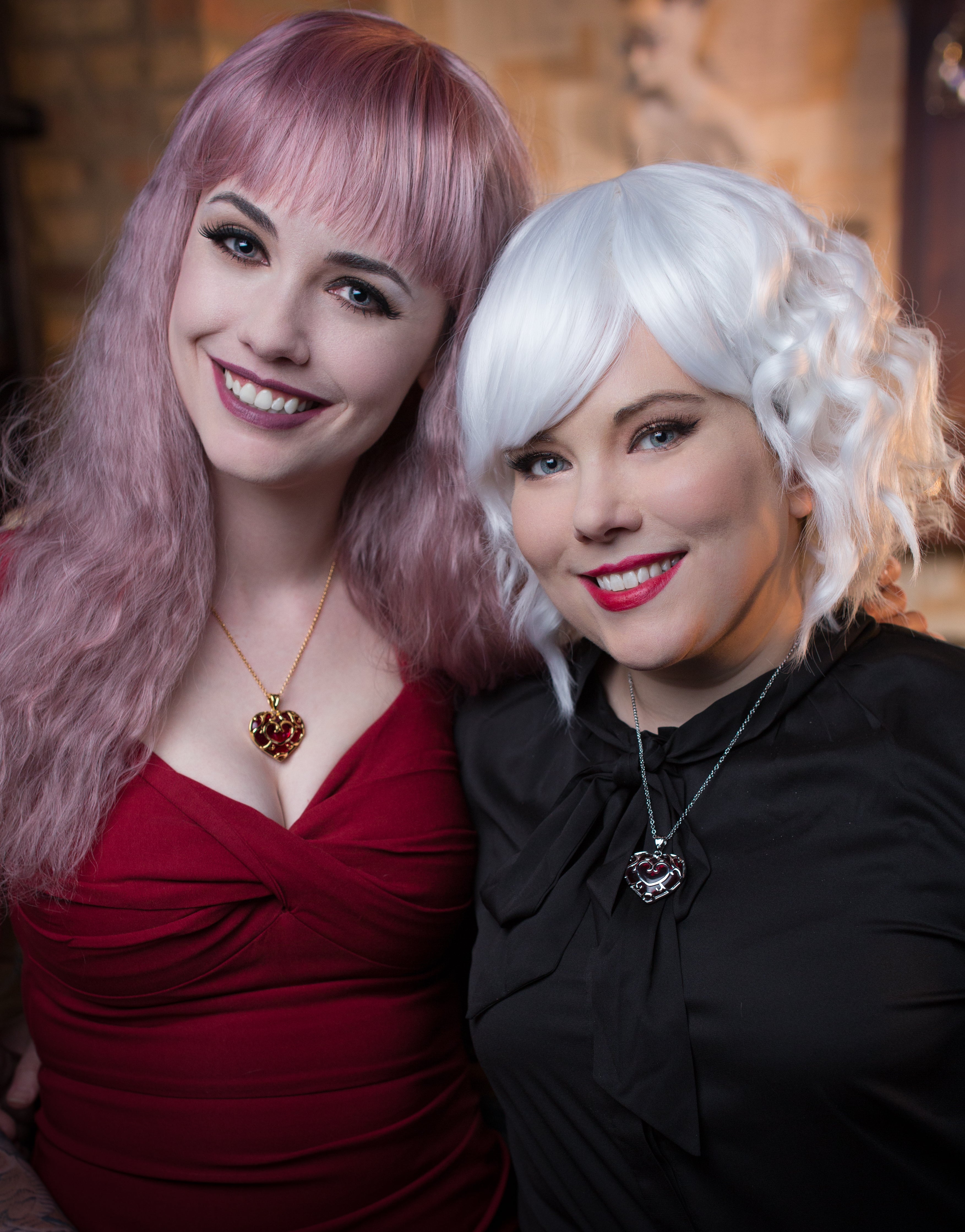 Two women with styled hair posing together indoors.