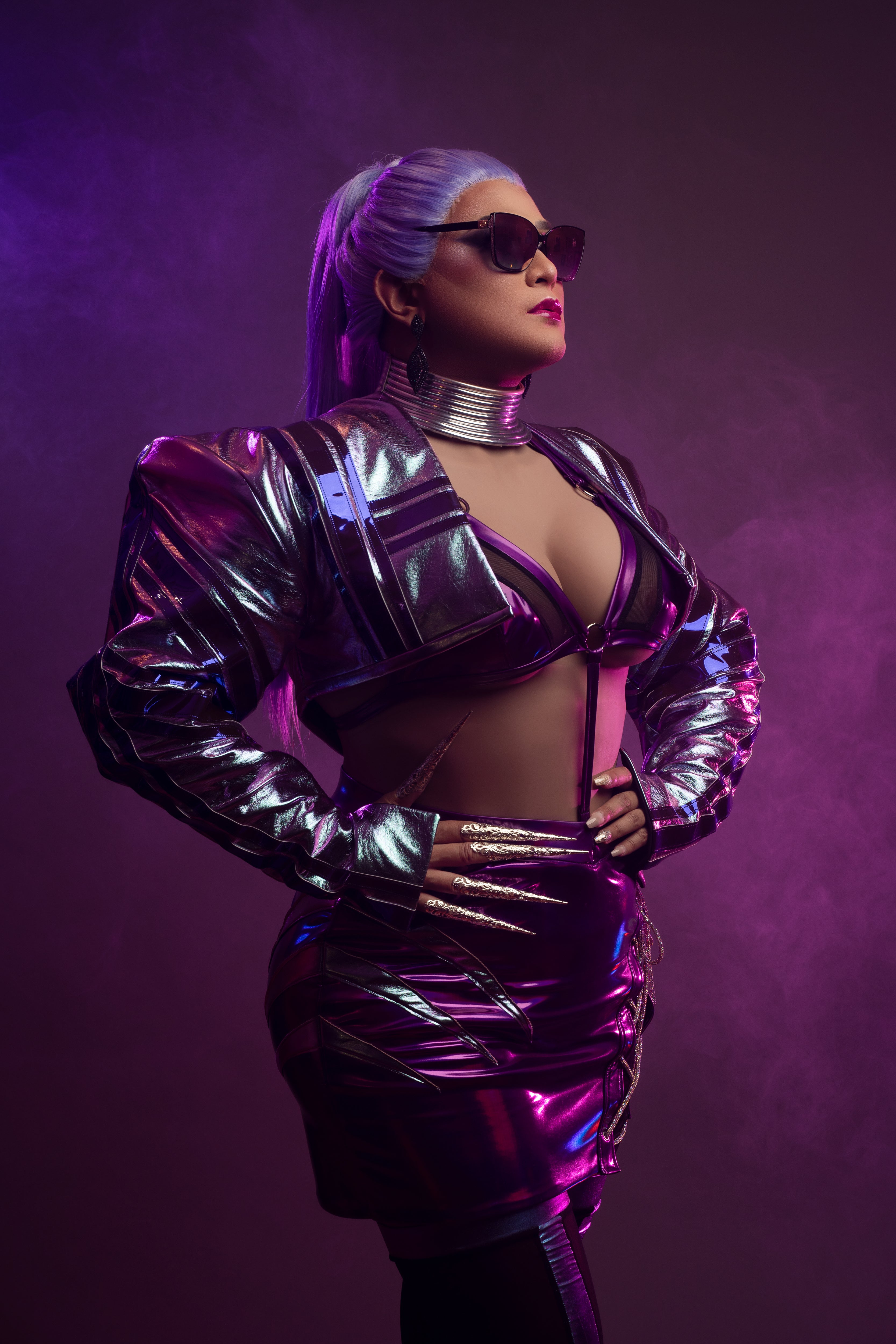 Person wearing a futuristic outfit with metallic textures against a purple background